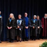 group of faculty waiting on stage for award